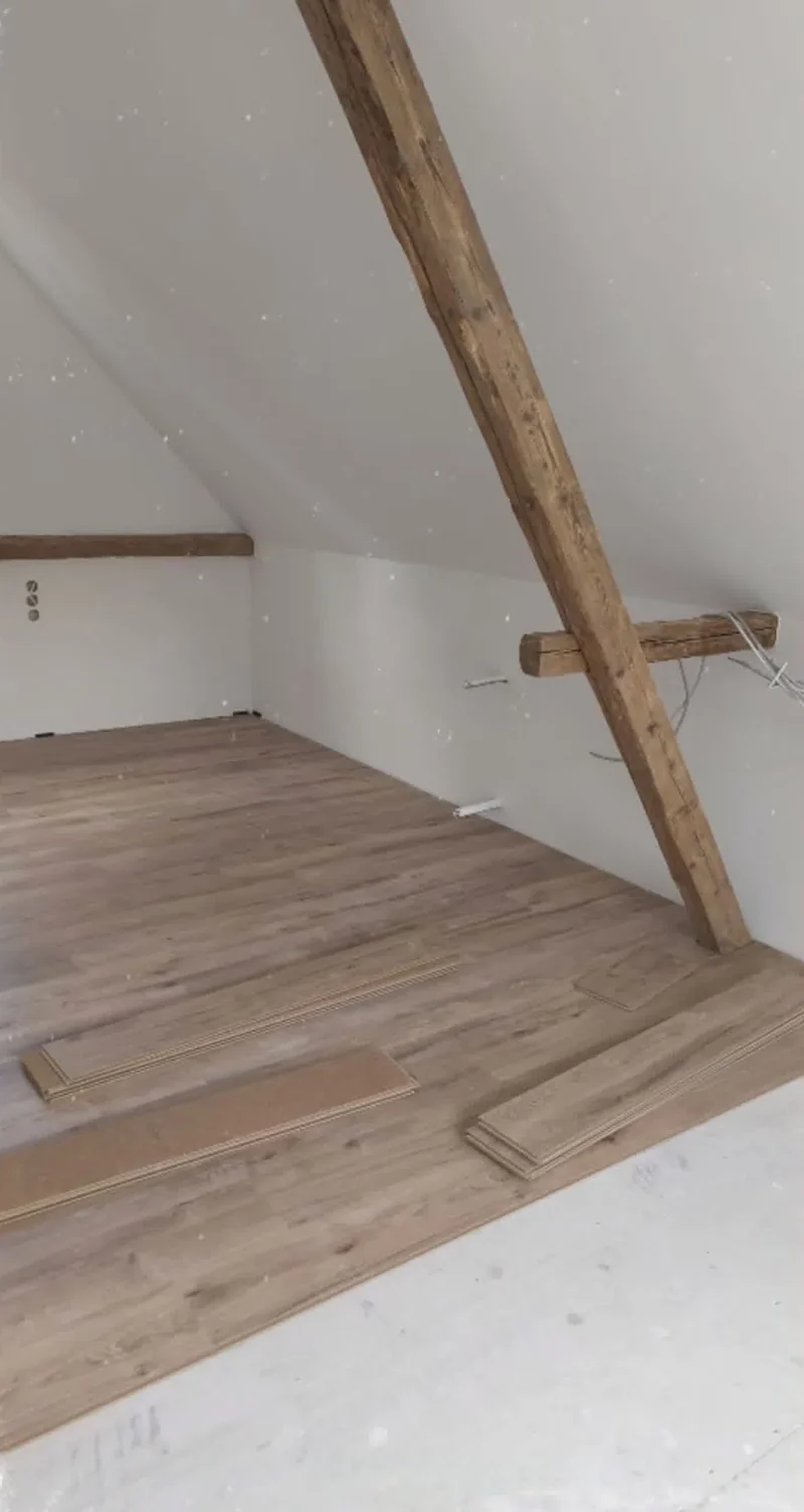 Detail der weißen Dachschräge, des Holzträgers und des Bodenabschlusses